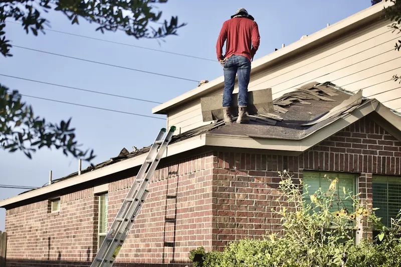 Professional roofer working on a residential roof in Mallory